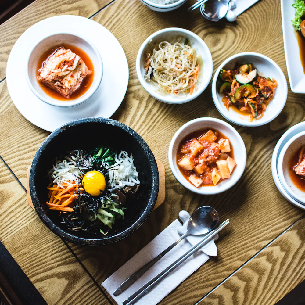 A Korean table set with bibimbap, kimchi and side dishes